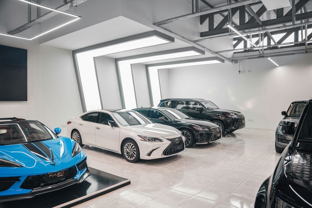 Several luxury cars on display in a modern dealership showroom