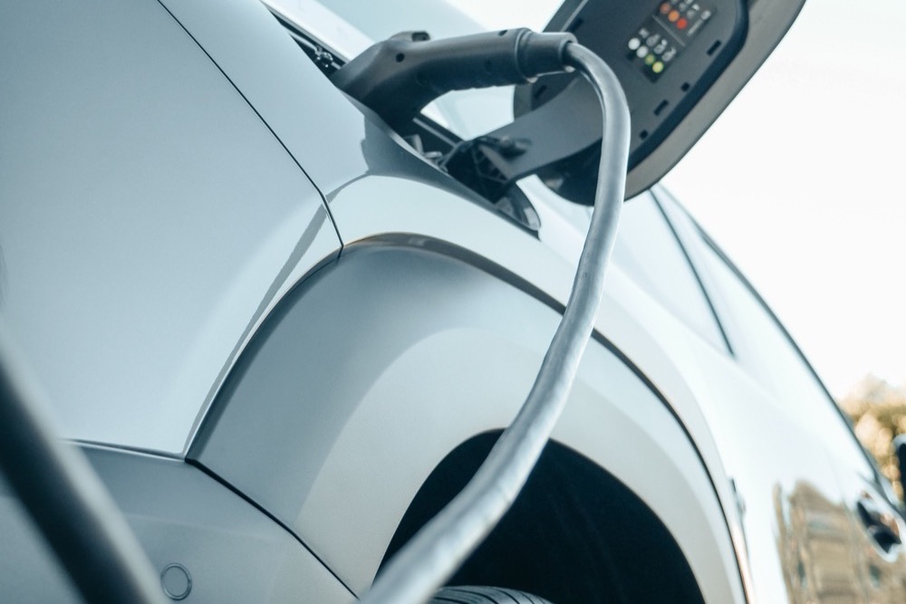 A charging cable plugged into the side of an electric car